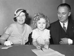 Five-year-old Temple signs a contract with Fox Films to receive $1,000 a week for the following seven years. The tiny cinema sensation is pictured with her parents, Mr. and Mrs. George F. Temple in 1934. Photograph: Bettmann/Corbis