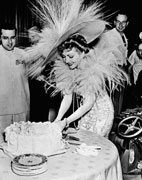 Claudette Colbert prepares to give the first slice of her birthday cake to Zaza director George Cukor