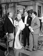 Edmund Goulding drops by the Dinner at Eight set to chat with Jean Harlow, Edmund Lowe and director George Cukor