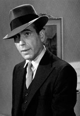 A thick band fedora, and a slim cut three-piece suit is the uniform of the private detective: Humphrey Bogart as Sam Spade in Maltese Falcon (1941)