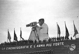 At the founding ceremony, Mussolini laid the first stone of the new headquarters of the L'Unione Cinematografica Educativa (LUCE), with giant poster of Mussolini and written propaganda 'Cinematography is the strongest weapon'