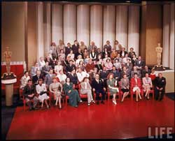 MGM: More stars than there are in heaven. In 1943 Louis B. Mayer gathered all of his stars for a group photo to celebrate the MGM's 20th birthday. </br>Front row: James Stewart, Margaret Sullavan, Lucille Ball, Hedy Lamarr, Katharine Hepburn, Louis B Mayer, Greer Garson, Irene Dunne, Susan Peters, Ginny Simms, Lionel Barrymore; </br>Second row: Harry James, Brian Donlevy, Red Skelton, Mickey Rooney, William Powell, Wallace Beery, Spencer Tracy, Walter Pidgeon, Robert Taylor, Pierre Aumont, Lewis Stone, Gene Kelly, Jackie Jenkins.