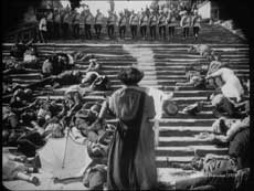In The Battleship Potemkin's 'Odessa Steps' sequence, a mother carries her injured child up the stairs in the face of the murderous soldiers advancing down. Soon she too will be shot.